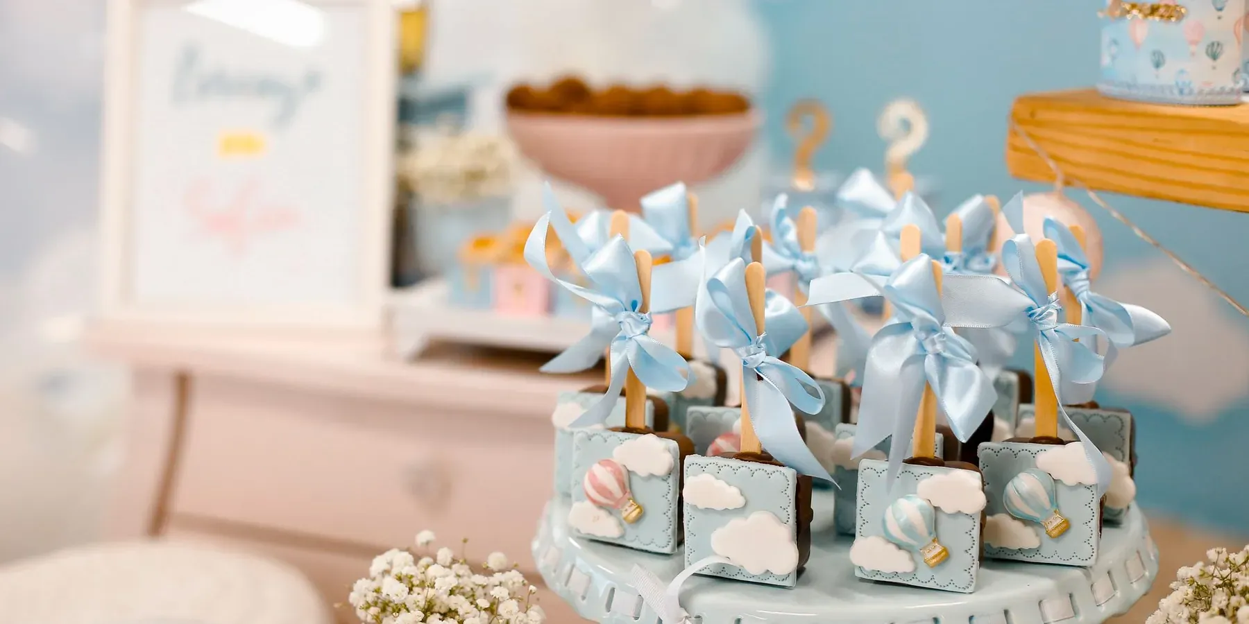 A baby shower dessert table decorated in soft pastels