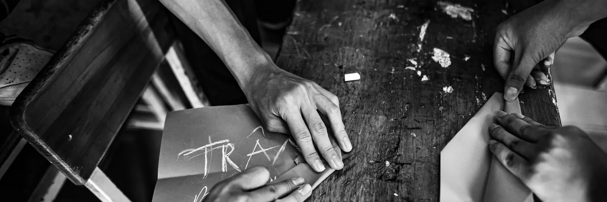 Hands assembling a paper piece by hand on a worktable