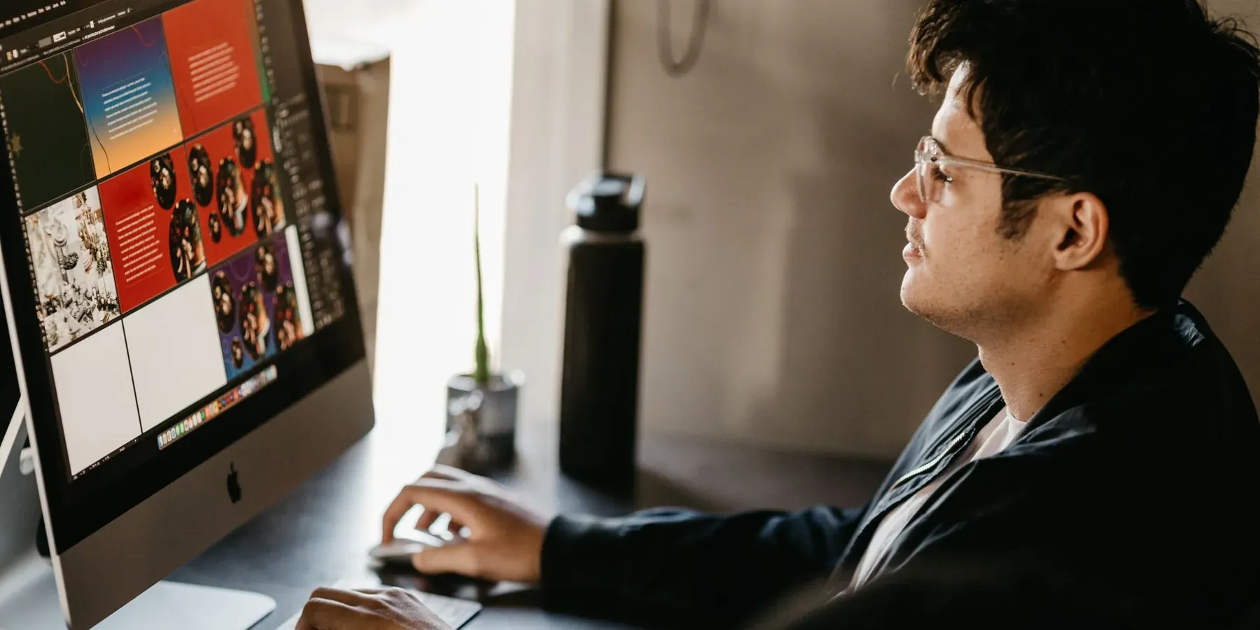 A designer working on layouts on a desktop computer