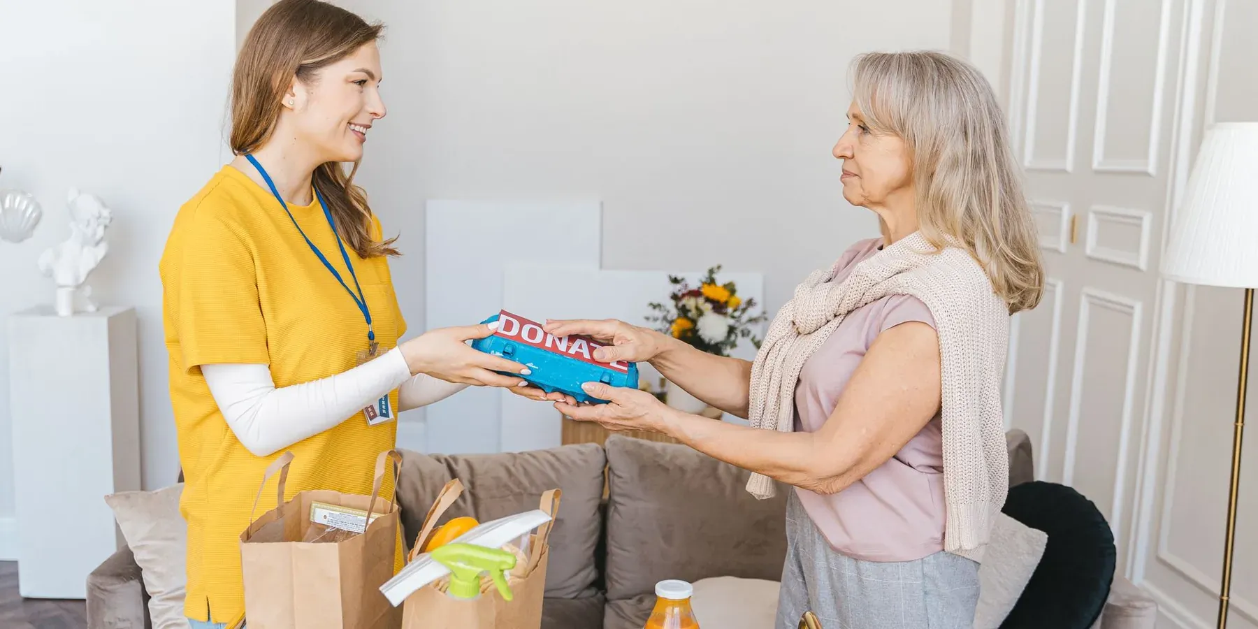 A volunteer handing a gift to a supporter during a donation drive