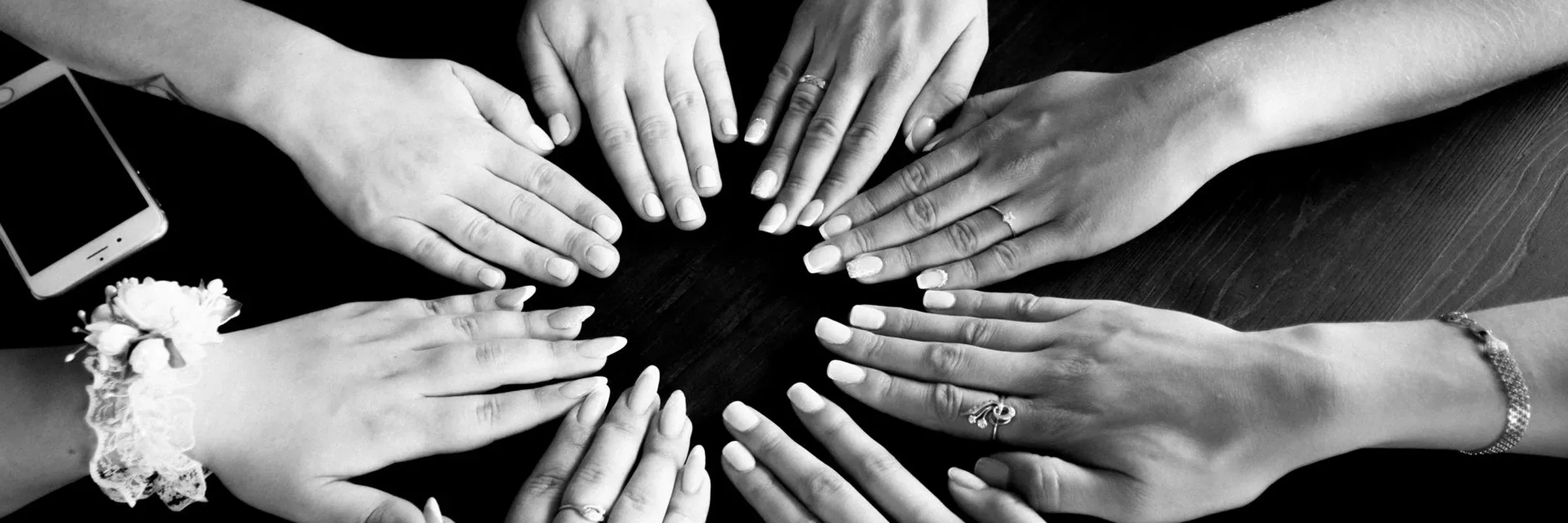 Hands joined in a circle on a table