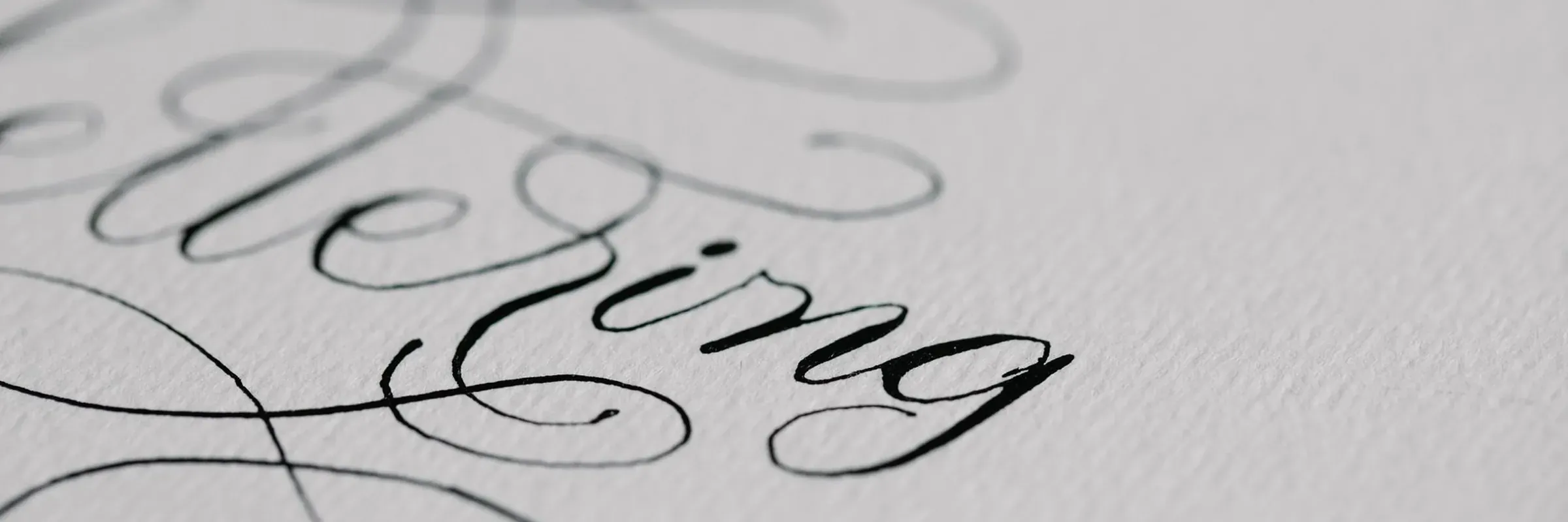 Black ink lettering drying on textured paper