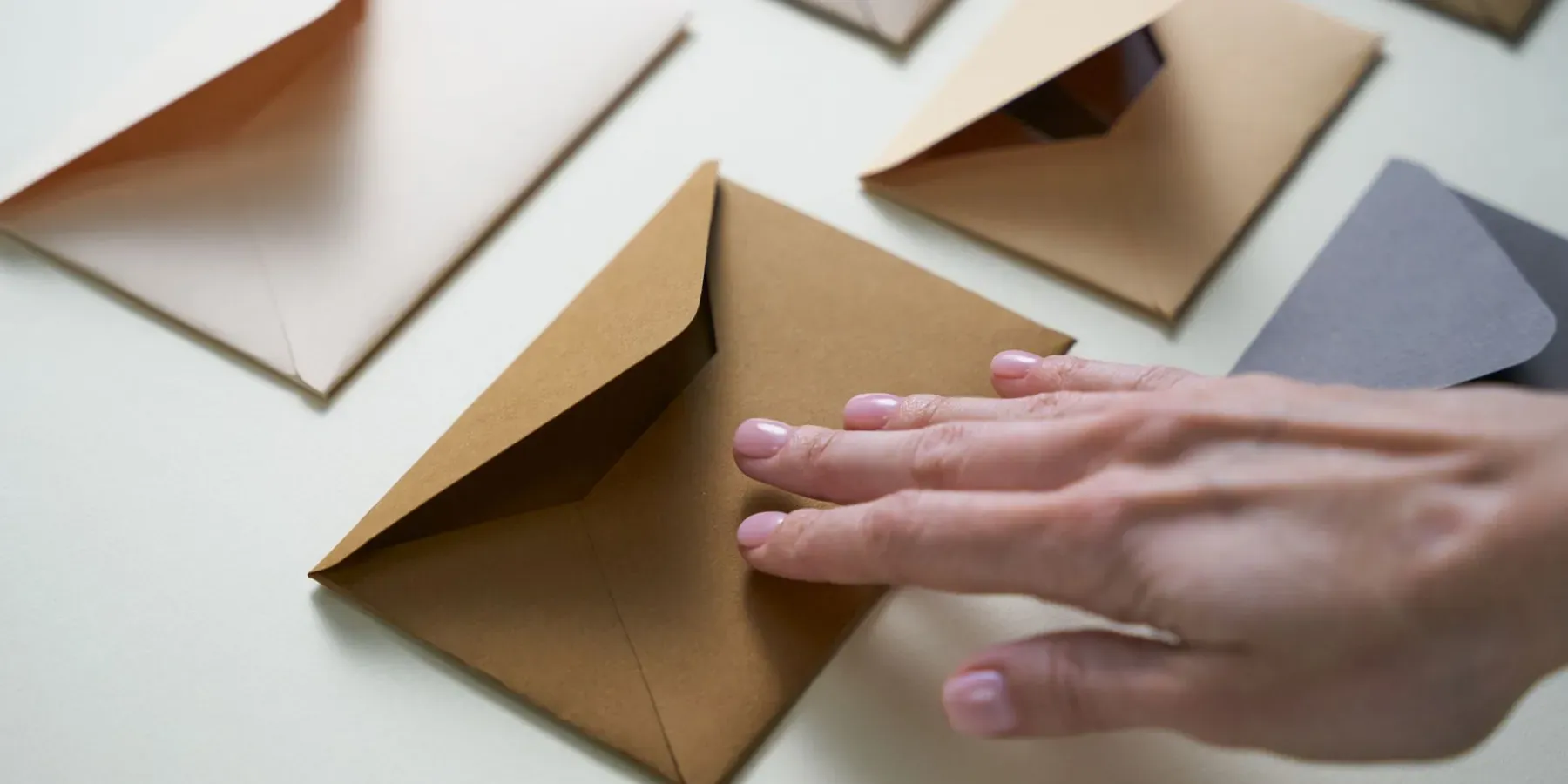 Kraft envelopes spread out and being sorted by hand for a mailing