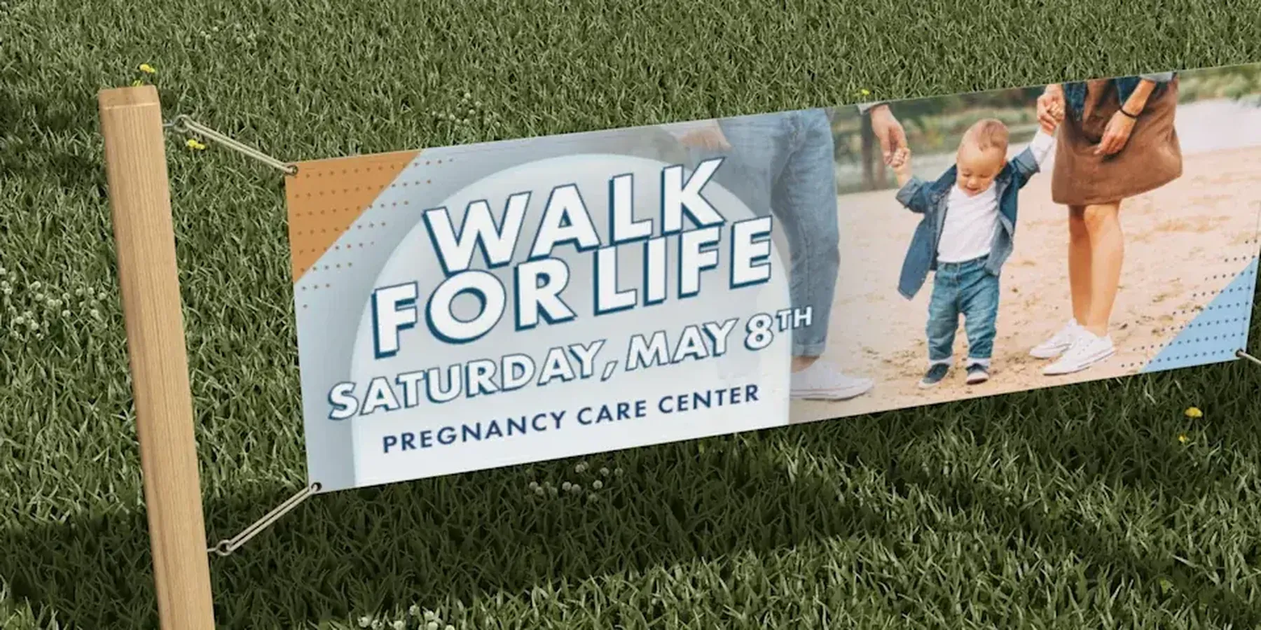 A large outdoor event banner and balloons set up in a park for a pregnancy center walk