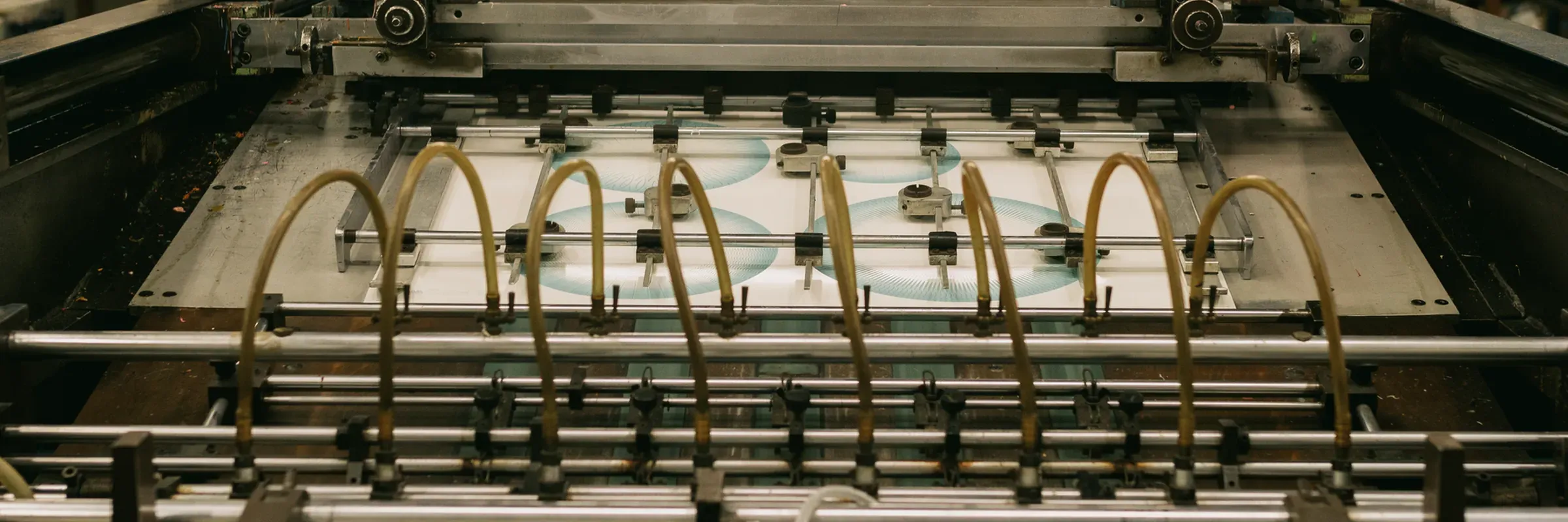 A printing press running a sheet of freshly printed work