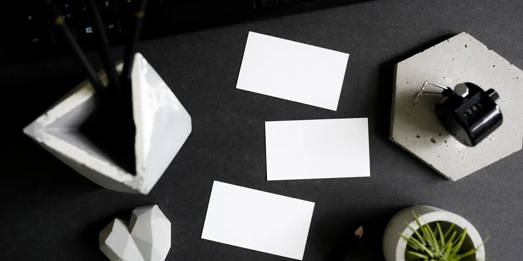 Blank business cards and letterhead arranged on a dark desk