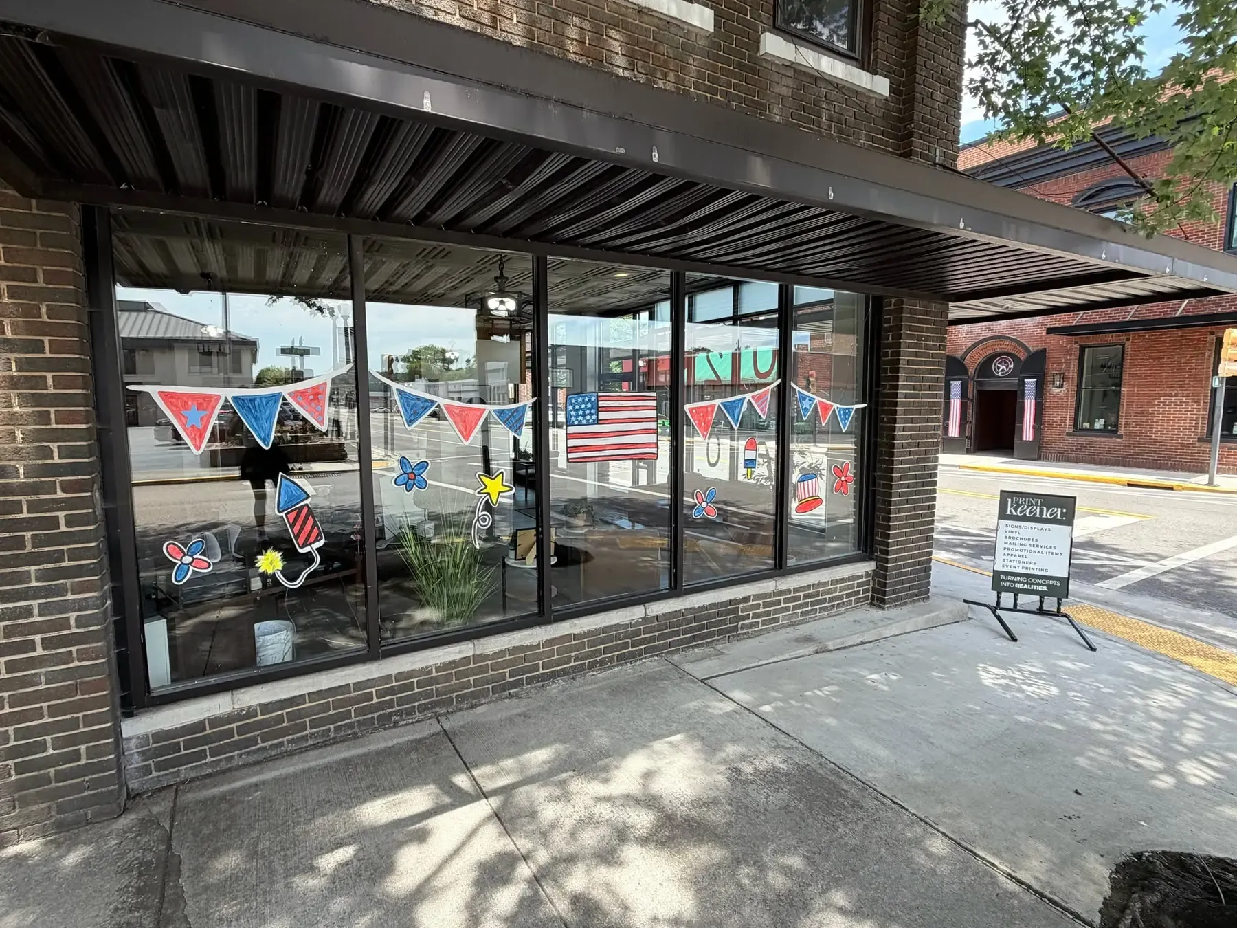 Hand-painted seasonal window art on the Keener Marketing storefront