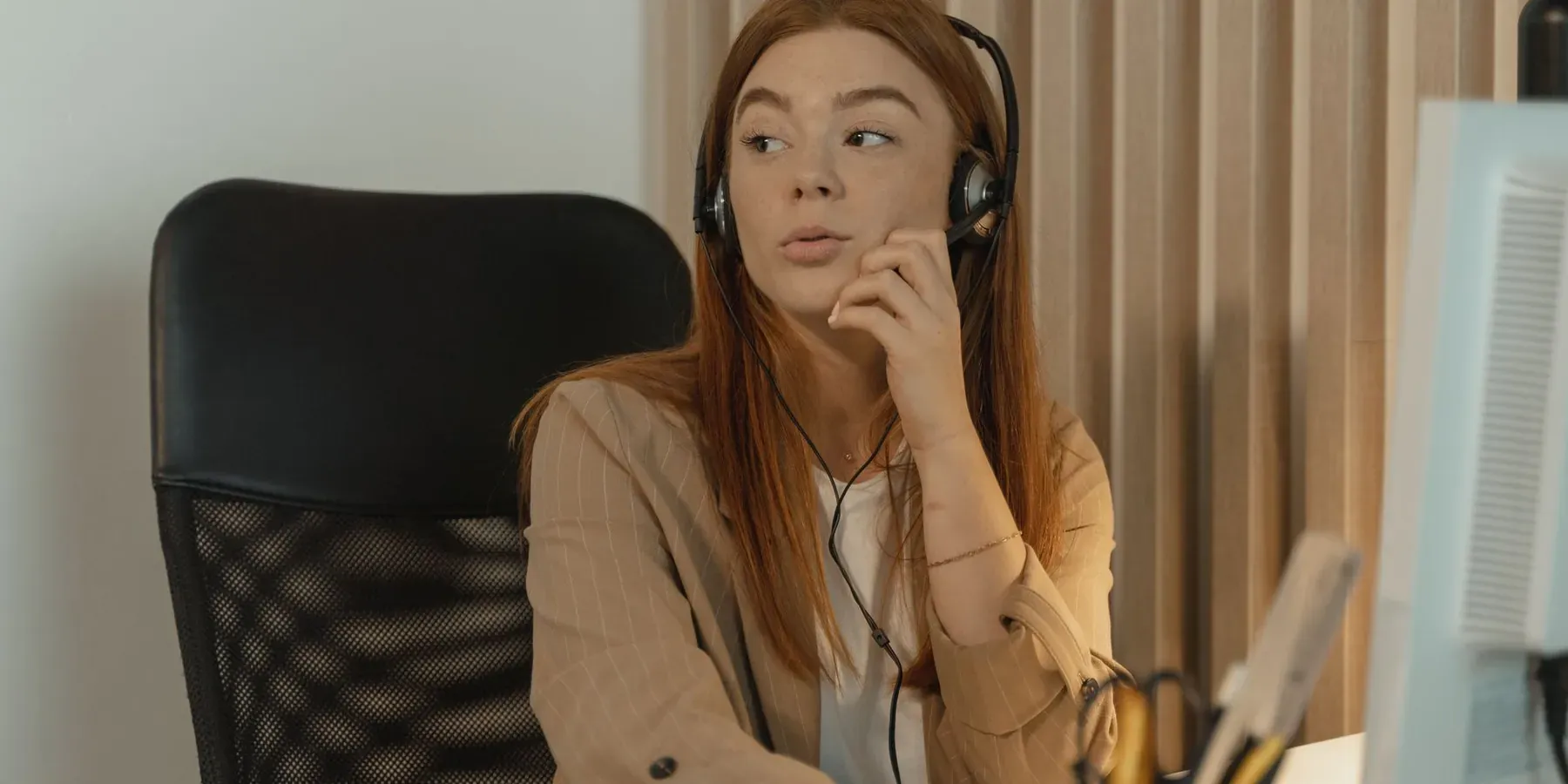 A member of a customer service team taking a call at her desk