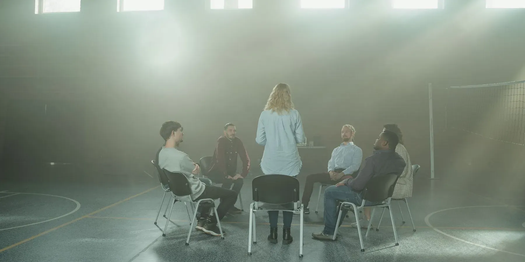 A small group seated in a circle in a sunlit room